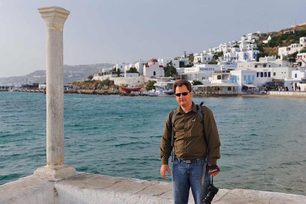 Kykladen-062009-073.jpg - Dirk an der Strandpromenade von Mykonos-Stadt. Was genau die Säule links von ihm trägt, hat sich uns nicht unmittelbar erschlossen.