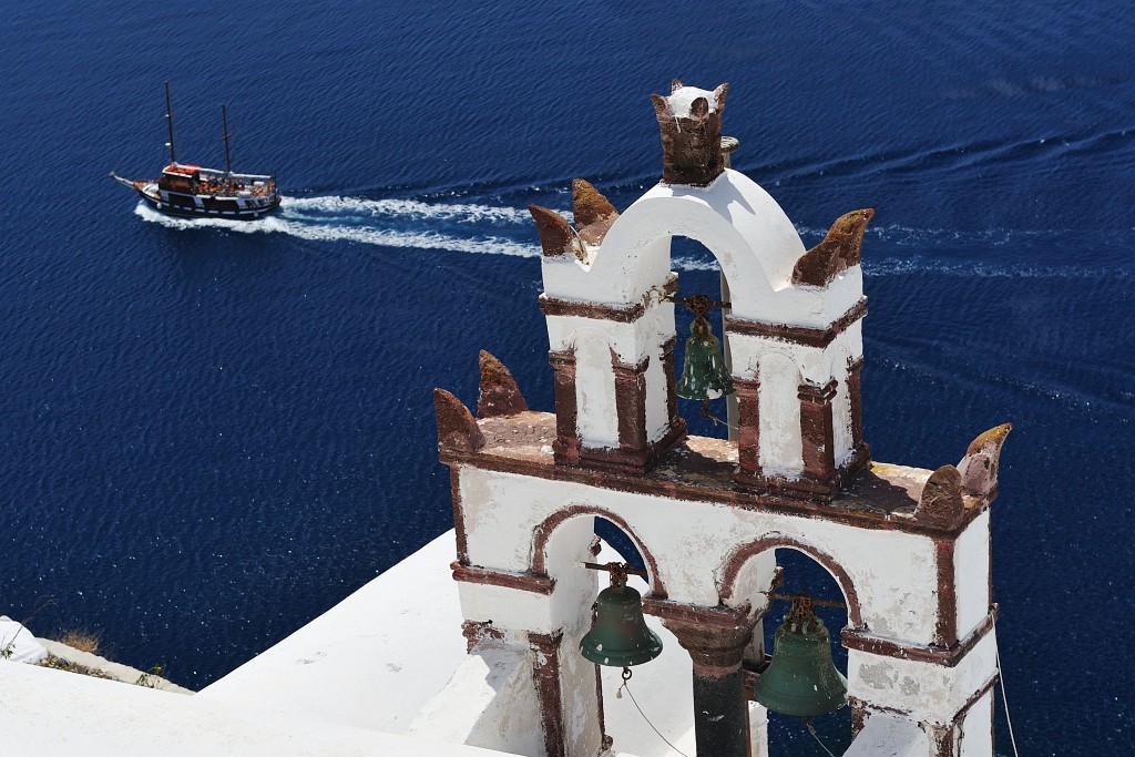 Kykladen-062009-108.jpg - Heute geht es hier zum Glück deutlich friedlicher zu. Unten sieht man eines jener Ausflugsboote, mit deren Hilfe man Touren zum aktiven Vulkankern in der Mitte der Caldera unternehmen kann. Wir haben diesen hochinteressanten Ausflug am Ende der Reise natürlich auch unternommen.