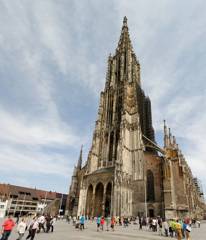 Ulm0409-33.jpg - Ein vertikales Panorama des Ulmer Münsters. Man lasse sich nicht von der Perspektive täuschen, die sicherlich mehr als 100 Grad vertikalen Bildwinkel stark zusammenstaucht. Dieser Turm ist 161 Meter hoch. Es ist leider nicht wirklich vergnüglich, diesen Turm zu besteigen, denn die Wendeltreppe ist endlos lang und sehr eng. Wenig vergnüglich ist auch das leider immer wieder nötige Vorbeiquetschen an den anderen Touristen, die in der Gegenrichtung passieren wollen. Für diejenigen, die wie ich an leichter Höhenangs leiden, ist der Blick aus den Fenstern des Treppenhauses auch nicht gerade beruhigend. Aber wer von oben Bilder machen möchte, dem bleibt keine andere Wahl, als die Mühsal auf sich zu nehmen.